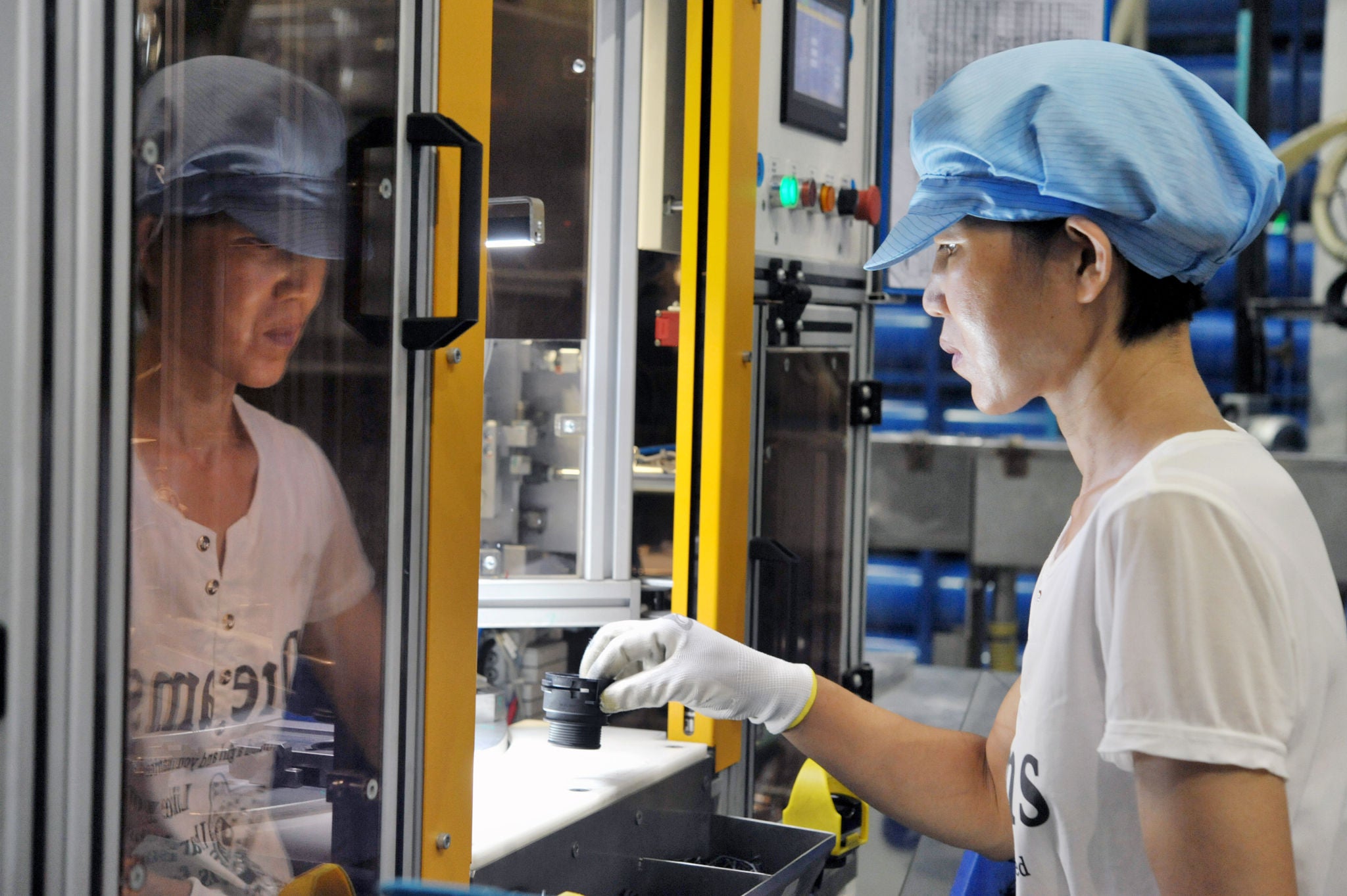 A Chinese worker makes products at the plant of NORMA in Qingdao city, east China's Shandong province, 27 July 2017.