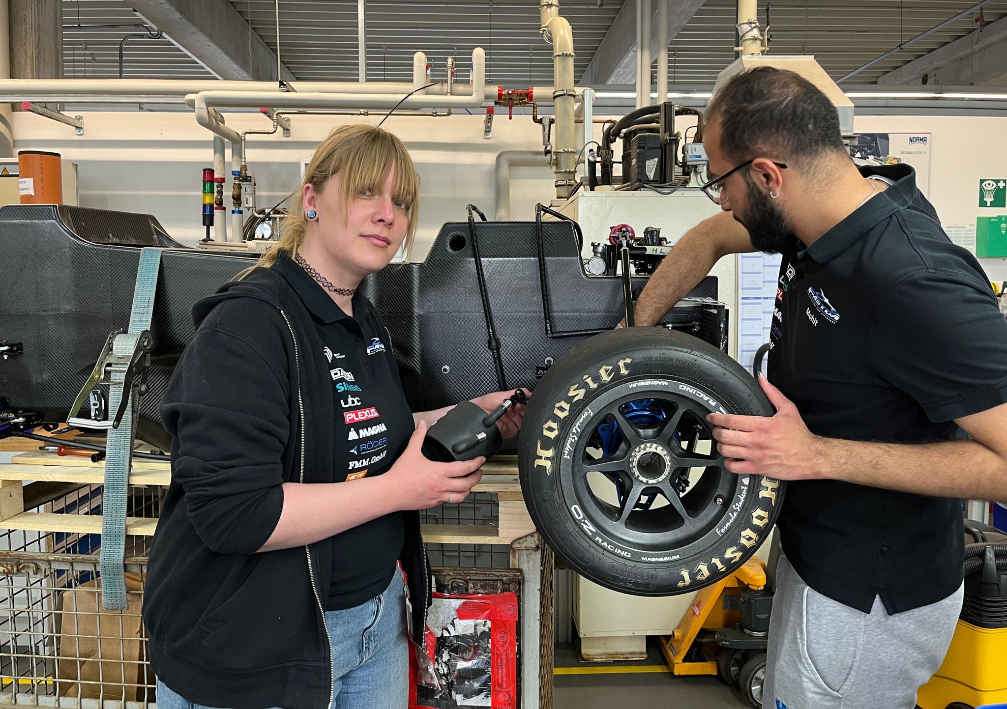 12 photos of the installation of NORMA cooling system in electric race car. People shown are 2 NORMA employees and several students from Hochschule Darmstadt