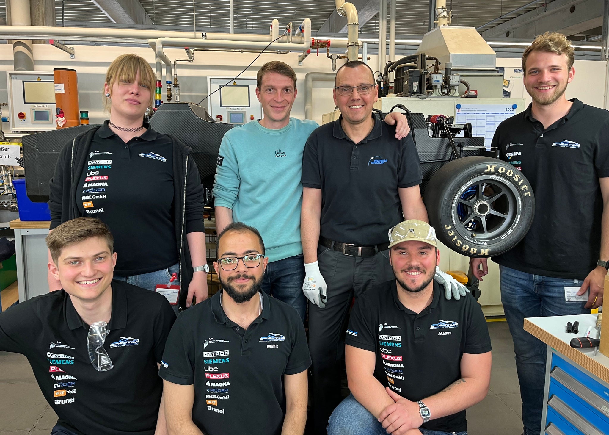 12 photos of the installation of NORMA cooling system in electric race car. People shown are 2 NORMA employees and several students from Hochschule Darmstadt